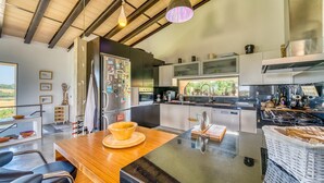 Una cocina moderna con una isla central, electrodomésticos de acero inoxidable y vistas al exterior.