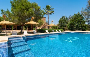 A clear blue pool with steps leading into it, surrounded by lounge chairs and thatched umbrellas. - Stunning home in Campos with private swimming pool, can be inside or outside (Campos)