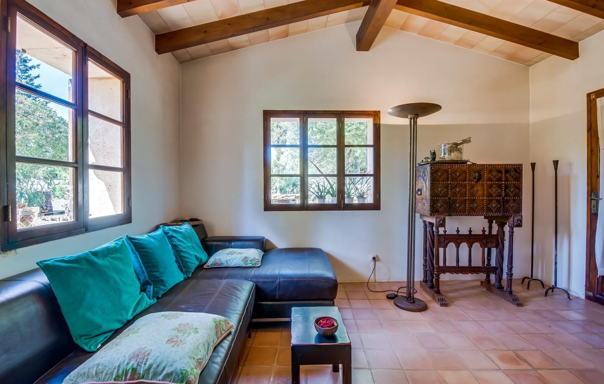 Una sala de estar con un sofá, una mesita con un bol, una lámpara de pie y un mueble.