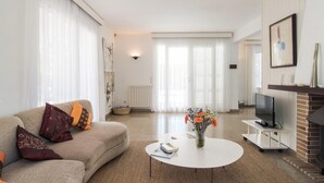 Ein modernes Wohnzimmer mit einer Couch, einem Couchtisch und einem Kamin.