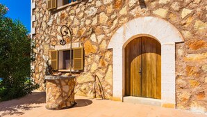 Un bâtiment en pierre avec une porte en bois et des volets aux fenêtres.