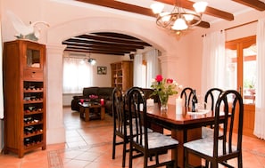 A dining area with a wooden table, chairs, and a chandelier. - Luxurious home in Campos with private swimming pool, can be inside or outside (Campos)