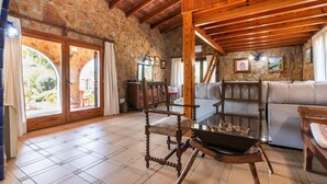 A rustic interior with stone walls, wooden beams, a glass table with shells, and a sofa. - Lovely home in Arta with private swimming pool, can be inside or outside (Arta)