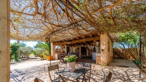 An outdoor patio with wooden furniture and a table with a potted plant. - Awesome home in Campos with private swimming pool, can be inside or outside (Campos)