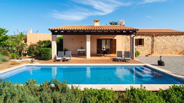 A poolside area with a covered patio, lounge chairs, and a stone building in the background. - Cozy home in Arta with private swimming pool, can be inside or outside (Arta)
