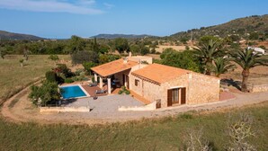 A stone villa with a swimming pool, surrounded by a hilly landscape and palm trees. - Cozy home in Arta with private swimming pool, can be inside or outside (Arta)