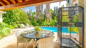 A poolside area with a glass table, two white chairs, and a birdcage. - Amazing home in Consell with private swimming pool, can be inside or outside (Consell)
