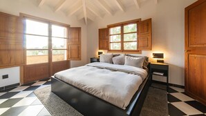 A bedroom with a bed, wooden cabinets, a window, and a checkered floor. - Nice home in Arta with private swimming pool, can be inside or outside (Arta)