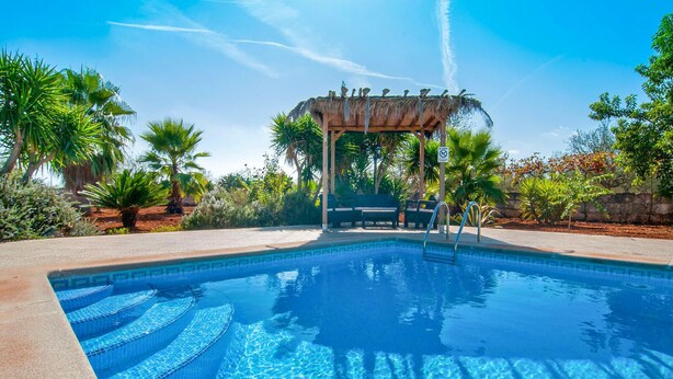 A clear blue pool with a pergola and lounge chairs in the background. - Beautiful home in Ariany with private swimming pool, can be inside or outside (Ariany)