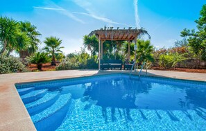 A clear blue pool with a pergola and lounge chairs in the background. - Beautiful home in Ariany with private swimming pool, can be inside or outside (Ariany)