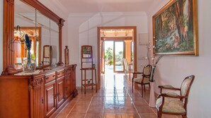 A spacious hallway with a wooden cabinet, a large mirror, and a painting on the wall. - Beautiful home in Ariany with private swimming pool, can be inside or outside (Ariany)