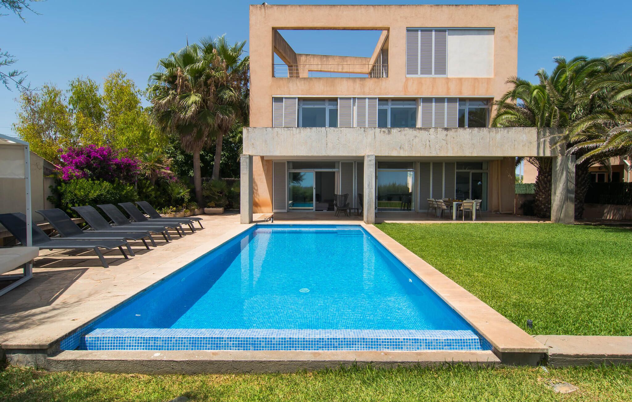 A modern two-story building with a swimming pool in front.