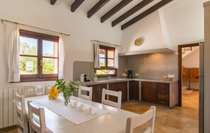 A kitchen with a dining table, chairs, a clock, and a view of the outdoors. - Amazing home in Arta with private swimming pool, can be inside or outside (Arta)