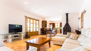 Una sala de estar con un sofá, una mesa de centro de madera, un televisor y una chimenea.