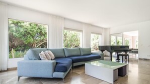 A spacious living room with a sectional sofa, a glass coffee table, and a grand piano. - Lovely home in Port Verd with private swimming pool, can be inside or outside (Port Verd)