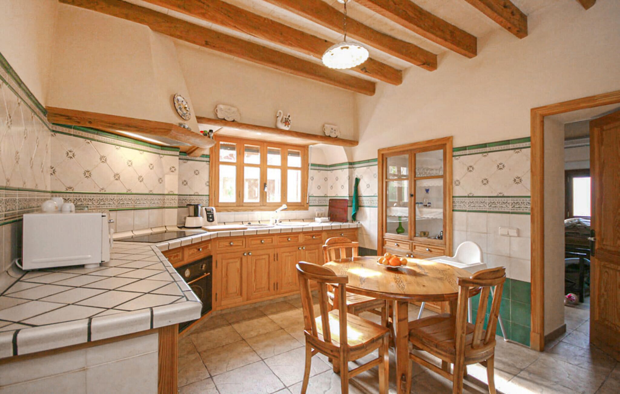A kitchen with wooden cabinets, a tiled backsplash, and a dining table with chairs.