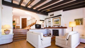 Una sala de estar con dos sofás, chimenea y televisor.