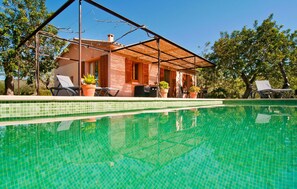 A house with a swimming pool, a covered patio, and outdoor furniture. - Awesome home in Sant Llorenc (Sant Llorenc)