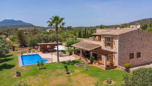A stone house with a pool, patio, and views of hills and trees. - Beautiful home in Cala Murada (Cala Murada)