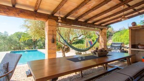 An outdoor patio with a pool, wooden table, chairs, and a hammock. - Amazing home in Manacor with private swimming pool, can be inside or outside (Manacor)