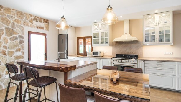 A modern kitchen with a central island, bar stools, a stove, and a microwave. - Lovely home in Buger with private swimming pool, can be inside or outside (Buger)