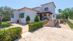 A two-story house with a stone pathway leading to the entrance, surrounded by greenery and a clear sky. - Amazing home in Portocolom with private swimming pool, can be inside or outside (Portocolom)
