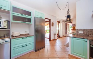 A kitchen with teal cabinets, a stainless steel refrigerator, a microwave, and a toaster. - Amazing home in Portocolom with private swimming pool, can be inside or outside (Portocolom)