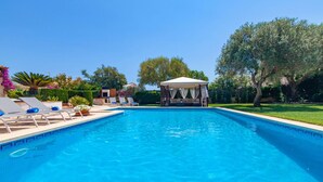 A rectangular swimming pool with clear blue water, surrounded by lounge chairs and a covered seating area. - Amazing home in Portocolom with private swimming pool, can be inside or outside (Portocolom)