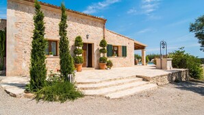 A stone building with a porch, steps leading to the entrance, and potted plants. - Beautiful home in Petra with private swimming pool, can be inside or outside (Petra)