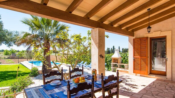 Eine Terrasse im Freien mit Esstisch, Schwimmbad und Blick auf die umliegende Landschaft.