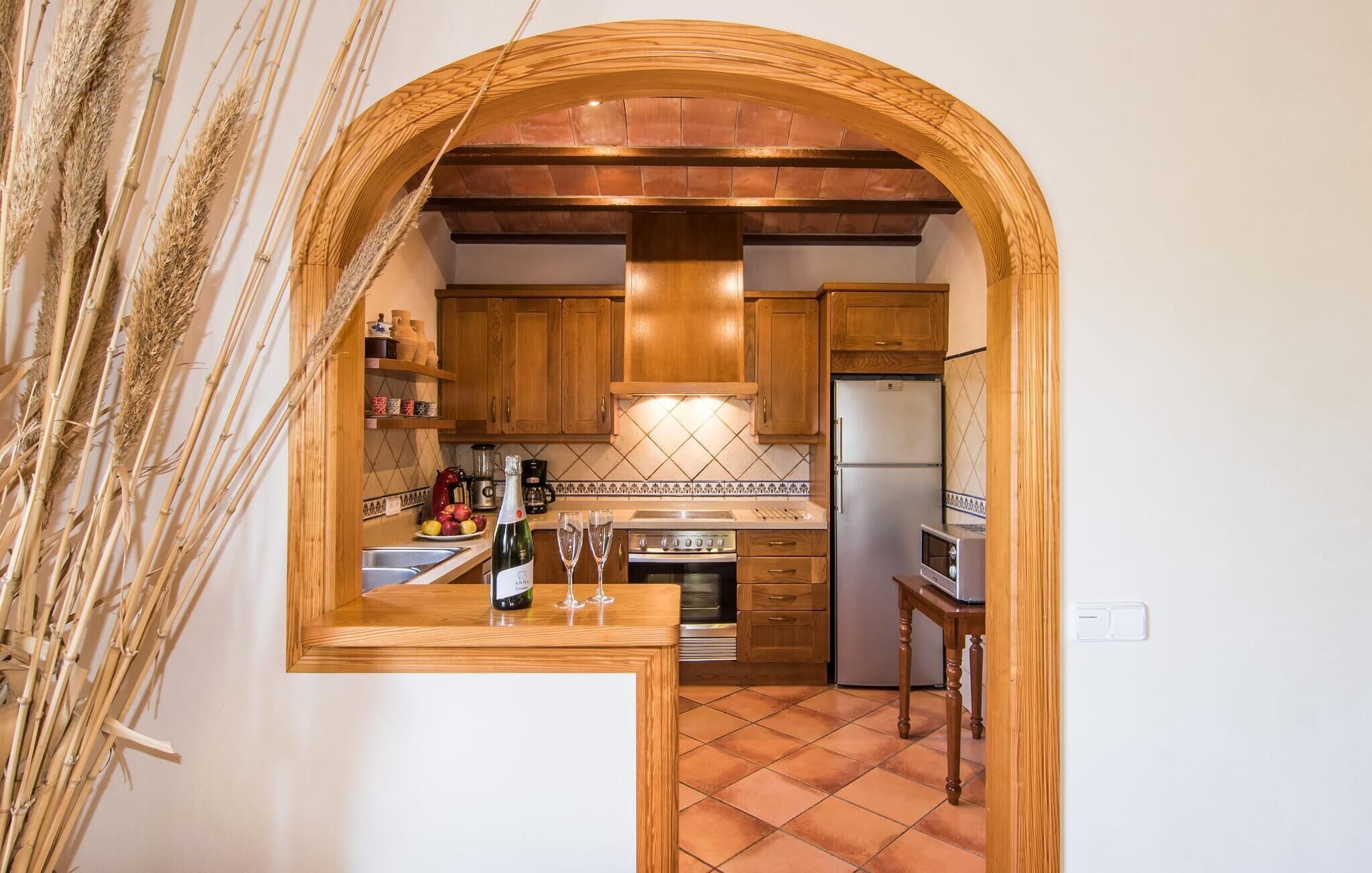 A kitchen with wooden cabinets, a tiled backsplash, a built-in oven, and a refrigerator.