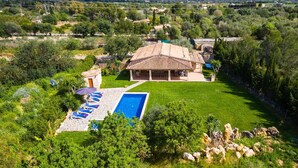A villa with a swimming pool, outdoor seating, and a view of the surrounding landscape. - Beautiful home in Pollenca with private swimming pool, can be inside or outside (Pollenca)