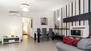 Uma sala de estar moderna com área de jantar, televisão e lareira.