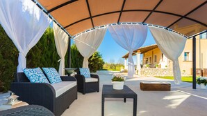 An outdoor patio with wicker furniture, a table, and a canopy. - Cozy home in Manacor with private swimming pool, can be inside or outside (Manacor)