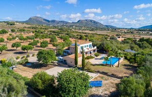 A two-story house with a swimming pool, surrounded by trees and mountains in the background. - Amazing home in Sant Llorenc (Sant Llorenc)