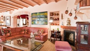 A cozy living room with a leather sofa, a glass coffee table, and a fireplace. - Beautiful home in Portocolom (Portocolom)