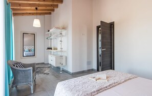 A bedroom with a bed, a chair, a wardrobe, a mirror, and a door. - Lovely home in Ses Salines with private swimming pool, can be inside or outside (Ses Salines)
