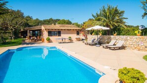 A swimming pool with lounge chairs and a stone wall. - Luxurious home in Arta with private swimming pool, can be inside or outside (Arta)
