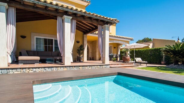 A swimming pool with a stone deck, a covered patio with outdoor furniture, and a well-maintained garden. - Nice home in Alcudia with private swimming pool, can be inside or outside (Alcudia)