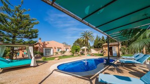 A pool area with a covered seating area, a pergola, and a house in the background. - Gorgeous home in Inca with private swimming pool, can be inside or outside (Inca)