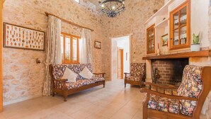 Ein Wohnzimmer mit Steinwand, Kamin, Sofa und Sessel.