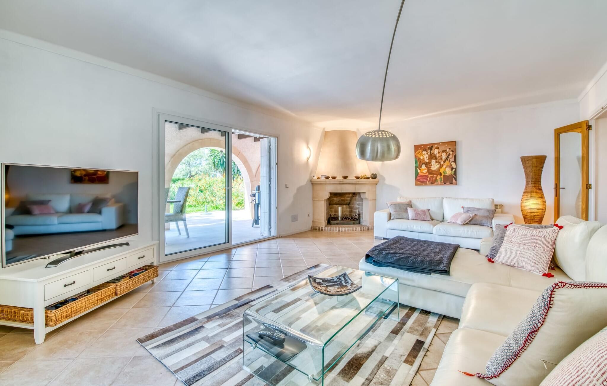 Ein geräumiges Wohnzimmer mit Fernseher, Sofa und Kamin.