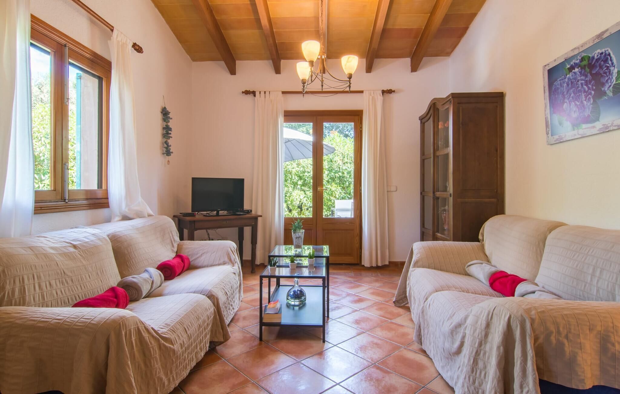 A cozy living room with two sofas, a coffee table, a TV, and a door leading outside.