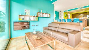 Un salon comprenant un canapé, une table basse et des étagères remplies de livres et d’objets décoratifs.