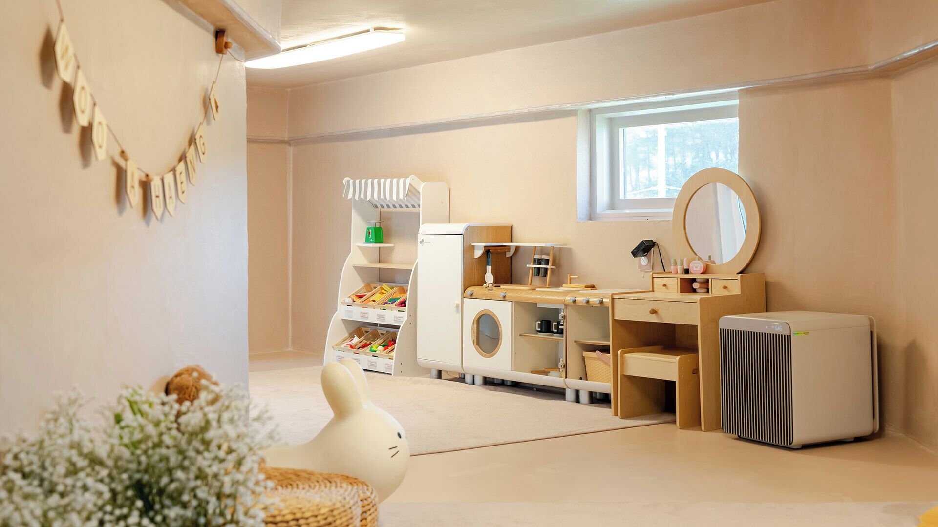 Une salle de jeux pour enfants avec une voiture jouet, une cuisine jouet et un lave-linge jouet.