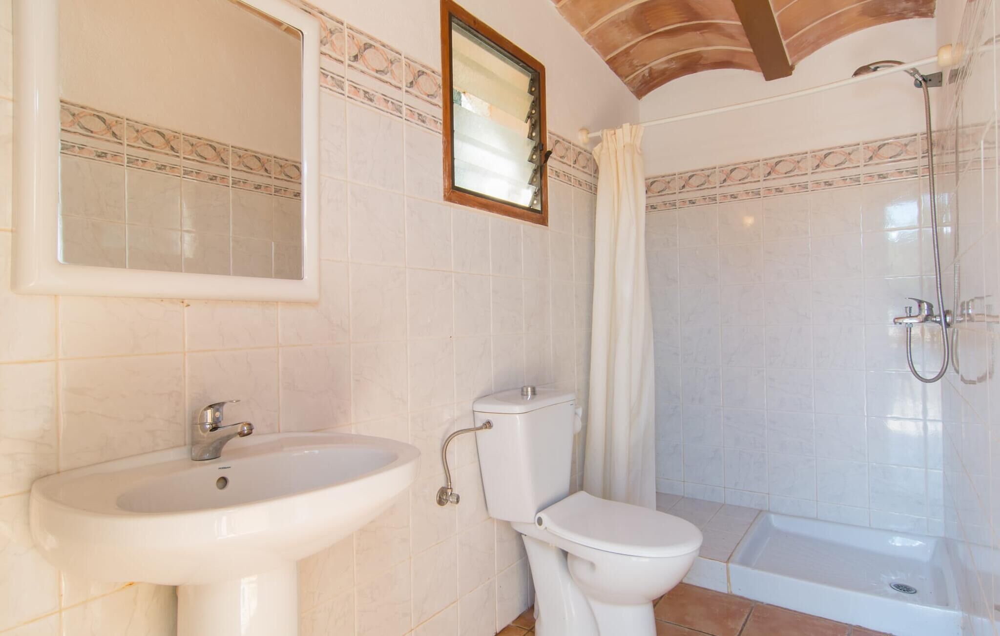 Une salle de bain avec un lavabo, des toilettes et une douche.