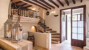 A staircase with a wooden railing, a small table with a candle, and a lantern. - Amazing home in Capdepera with private swimming pool, can be inside or outside (Capdepera)