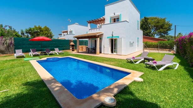 Una moderna casa a due piani con piscina, area salotto esterna e un pergolato.