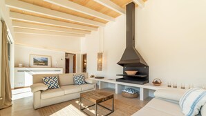 Un salon moderne avec un canapé, une table basse et une cheminée.