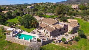 A stone villa with a swimming pool, surrounded by lush greenery and a hilly landscape. - Gorgeous home in Sant Llorenc (Sant Llorenc)